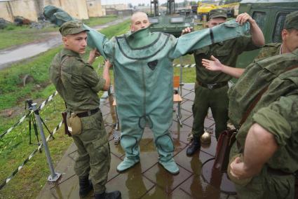 Солдат железнодорожных войск одевает водолазный костюм