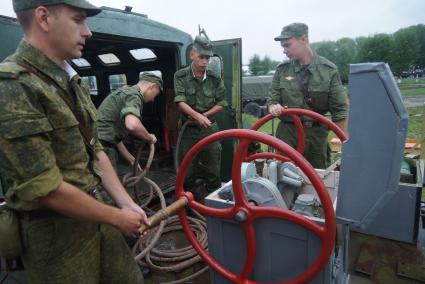 Солдаты-срочники железнодорожных войск разворачивают мобильную водолазную станцию