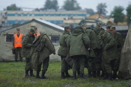 Солдат у палаточного лагеря одеваются в теплую одежду