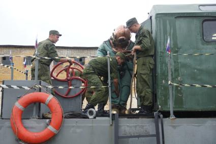 Солдат железнодорожных войск в водолазном костюме готовится к учебному погружению под воду