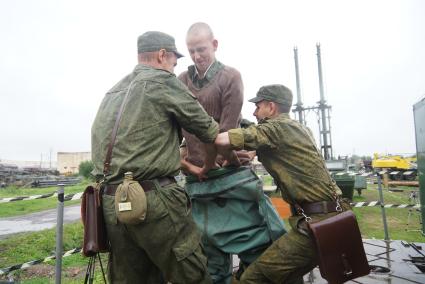 Солдат железнодорожных войск одевает водолазный костюм