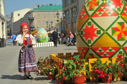 Никольская улица. Ярмарка \'Продукты и подарки к Пасхе\', открывшаяся   в рамках фестиваля \'Пасхальный дар\'. На снимке: девочка у пасхального яйца.