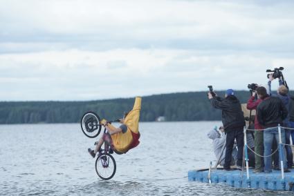 Прыжки на велосипедах в воду Bicycle live fest, парень в костюме банана прыгает на велосипеде с трамплина