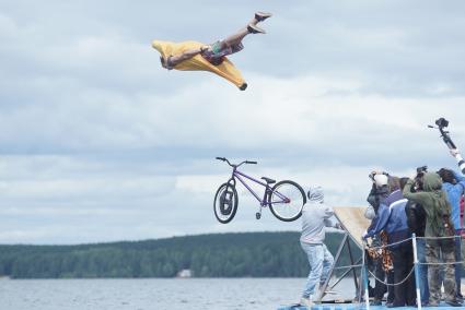 Прыжки на велосипедах в воду Bicycle live fest, парень в костюме банана прыгает на велосипеде с трамплина