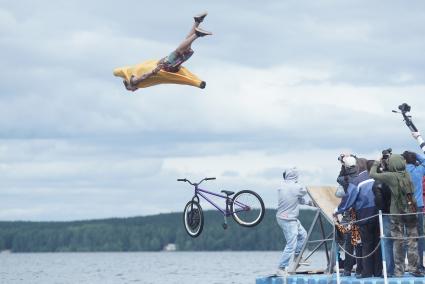 Прыжки на велосипедах в воду Bicycle live fest, парень в костюме банана прыгает на велосипеде с трамплина