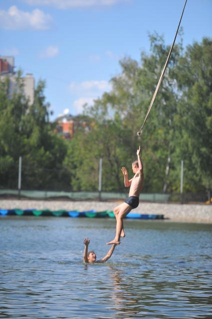 Тропаревский парк. На снимке:  молодой человек прыгает в воду с тарзанки.