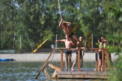 Тропаревский парк. На снимке:  молодой человек прыгает в воду с тарзанки.