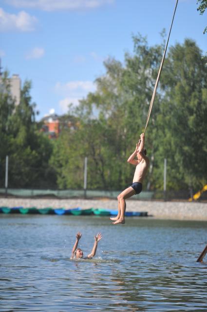 Тропаревский парк. На снимке:  молодой человек прыгает в воду с тарзанки.