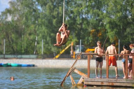 Тропаревский парк. На снимке:  молодой человек прыгает в воду с тарзанки.