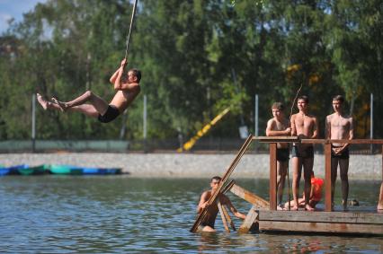 Тропаревский парк. На снимке:  молодой человек прыгает в воду с тарзанки.