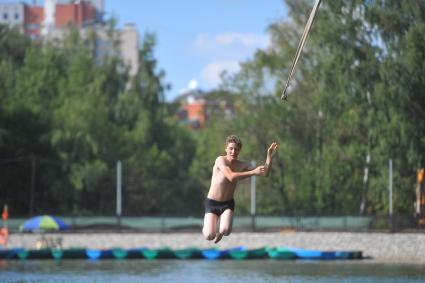 Тропаревский парк. На снимке:  молодой человек прыгает в воду с тарзанки.