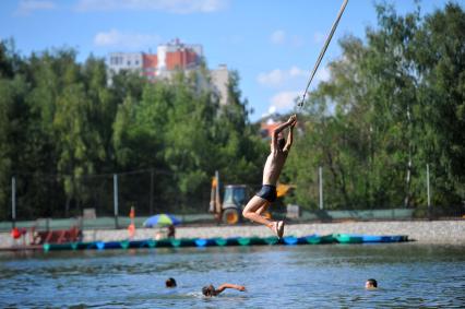 Тропаревский парк. На снимке:  молодой человек прыгает в воду с тарзанки.