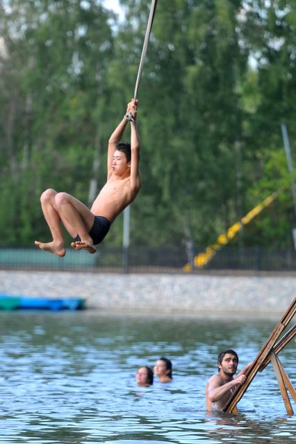 Тропаревский парк. На снимке:  молодой человек прыгает в воду с тарзанки.