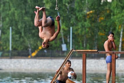 Тропаревский парк. На снимке:  молодой человек прыгает в воду с тарзанки.