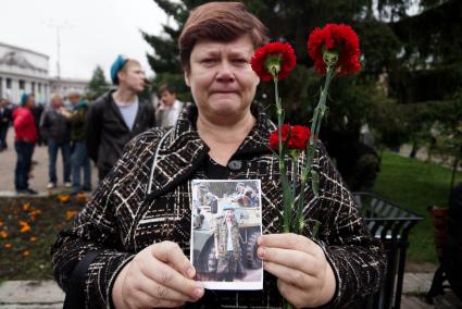 женщина плачет и держит фотографию мужа - ветерана ВДВ во время празднования дня воздушно-десантных войск