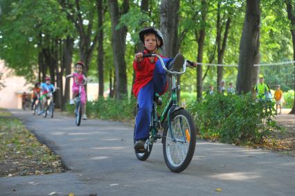 Сеть лагерей  КИД-клуб KIDS. Подмосковный лагерь \'Контакт\'. На снимке: дети катаются на велосипедах.