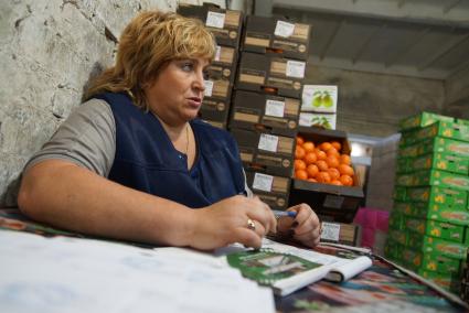 учетчица поставок на 4-1 овощебазе в Екатеринбурге среди ящиков с фруктами