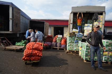 рабочие 4-й овощебазы в Екатеринбурге разгружают фуру с овощами и фруктами