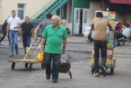 пенсионер на 4-й овощебазы в Екатеринбурге идет с продуктовой тележкой