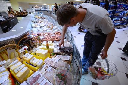 Магазин `Соседушка` в Оренбурге. На снимке: мужчина выбирает колбасную нарезку.