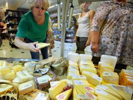 Магазин `Соседушка` в Оренбурге. На снимке: женщина выбирает сыр на витрине.