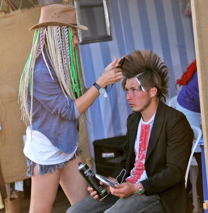 Девушка парикмахер делает ирокез молодому человеку.
