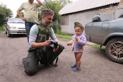 Село Семеновка. На снимке: специальный фотокорреспондент  МИА `Россия сегодня` Андрей Стенин и Антоша Собченко в каске.