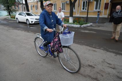 Бабушка едет на велосипеде в городе Ирбит