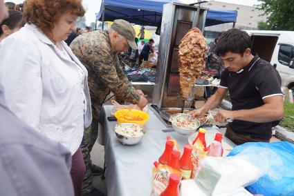 торгаш готовит шаурму на Ирбитской ярмарке в городе Ирбит