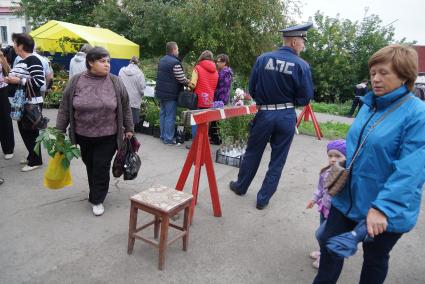Полицейский стоит у шлакбаума при входе на территорию Ирбитской ярмарке