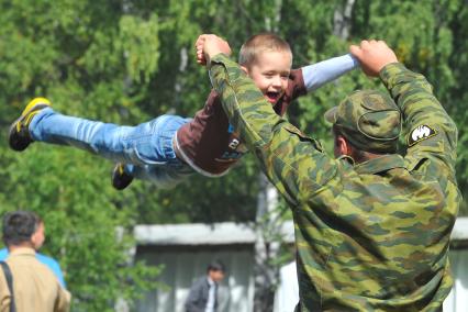 Учебный центр служебного собаководства в Дмитрове. Парад с участием 400 служебных собак, посвященный 90-ой годовщине образования. На снимке: военнослужащий с ребенком.