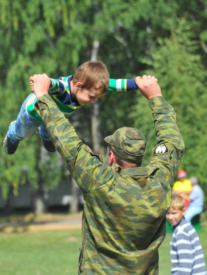 Учебный центр служебного собаководства в Дмитрове. Парад с участием 400 служебных собак, посвященный 90-ой годовщине образования. На снимке: военнослужащий с ребенком.