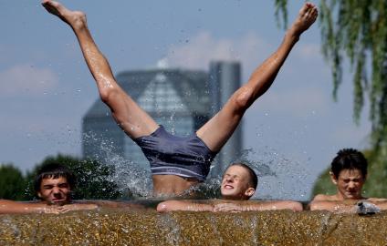 Молодежь купается в реке Свислочь вблизи Национальной бибилотеки Беларуси в Минске.