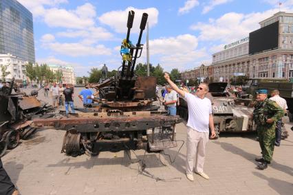 Донецк. Центральная площадь Ленина, куда ополченцы привезли уничтоженную украинскую бронетехнику. На снимке: мужчина показывает фигу в сторону зенитной установки.