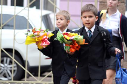 Дети идут в школу с букетами цветов.