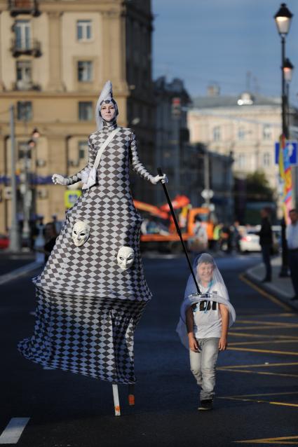 Открытие пешеходной зоны на улице Покровка. На снимке: клоун на ходулях одевает сачок на ребенка.