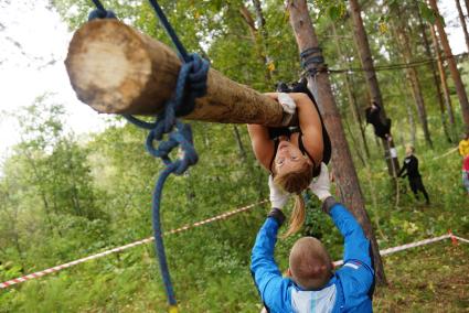 Участница грязных гонок Ural Dirty Race 2014 под Екатеринбургом ползет по подвешаному бревну