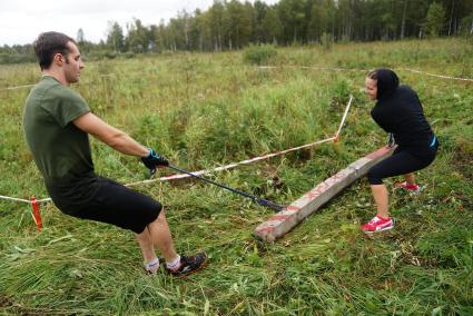 Участники грязных гонок Ural Dirty Race 2014 под Екатеринбургом  переносят бетонный брус