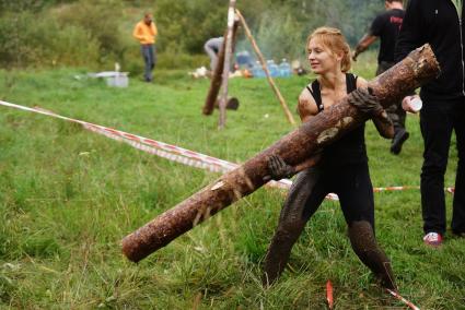 Участница грязных гонок Ural Dirty Race 2014 под Екатеринбургом  поднимает бревно