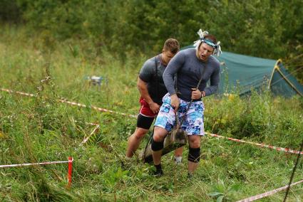 Участники грязных гонок Ural Dirty Race 2014 под Екатеринбургом переносят бетонный брус