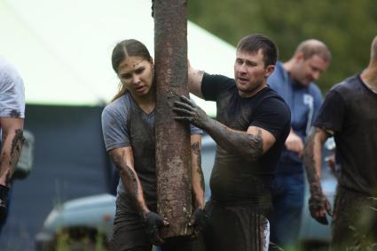 Участница грязных гонок Ural Dirty Race 2014 под Екатеринбургом  поднимает бревно