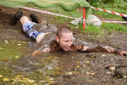 Участник грязных гонок Ural Dirty Race 2014 под Екатеринбургом  ползет по грязи