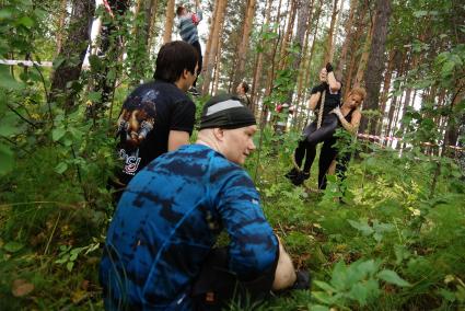 Участники грязных гонок Ural Dirty Race 2014 под Екатеринбургом наблюдают как девушки поднимаются по канату