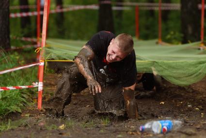 Участник грязных гонок Ural Dirty Race 2014 под Екатеринбургом  ползет по грязи