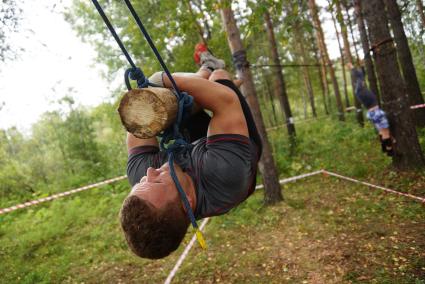 Участник грязных гонок Ural Dirty Race 2014 под Екатеринбургом ползет по подвешаному бревну