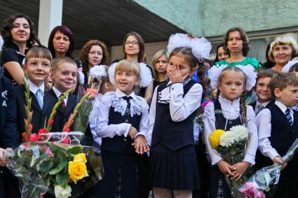 Девочка трет глаза на линейке школы 88 в Воронеже