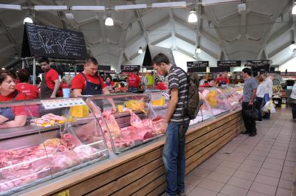 Даниловский рынок. Мясной ряд. На снимке: покупатель выбирает свежее мясо.