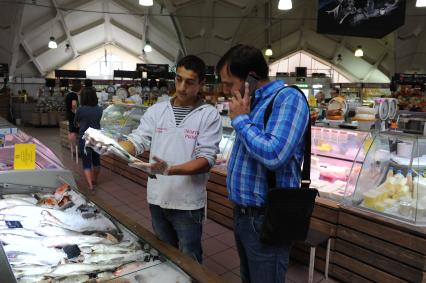 Даниловский рынок. Рыбные ряды. На снимке: продавец рыбного отдела показывает покупателю лосось.