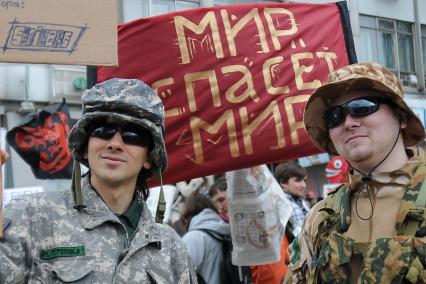 Люди в военной форме с транспарантом: `Мир спасет мир!`