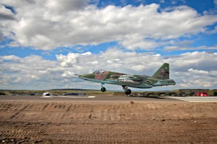 Военный штурмовик Су-25 `Грач` совершает посадку на автомобильную дорогу.